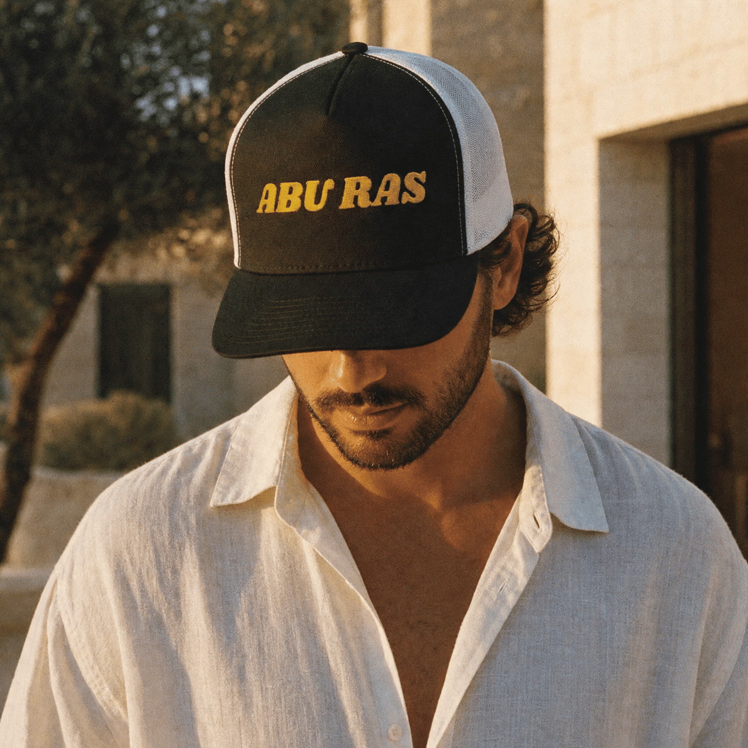 Model wearing Abu Ras trucker cap, Arabic slogan headwear by BOSA