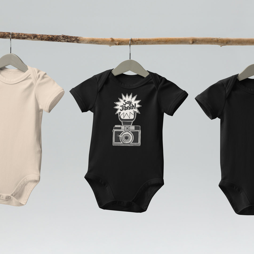 Say Jibneh organic cotton baby bodysuit in black, front view, Arab food humor baby clothing by BOSA