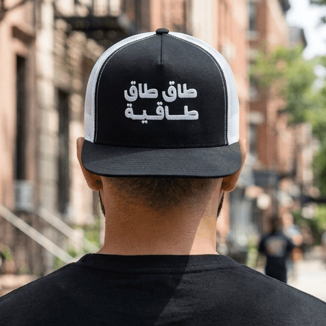 Model wearing Taq Taq Taqiyah trucker cap, Arabic wordplay headwear by BOSA