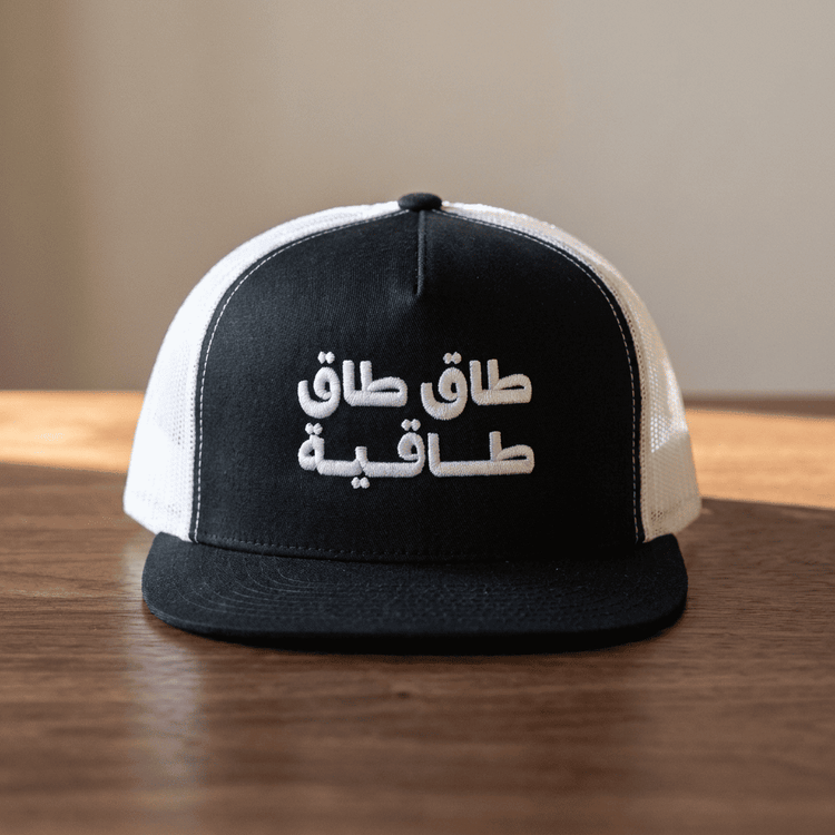 Model wearing Taq Taq Taqiyah trucker cap, side angle, Arabic wordplay headwear by BOSA
