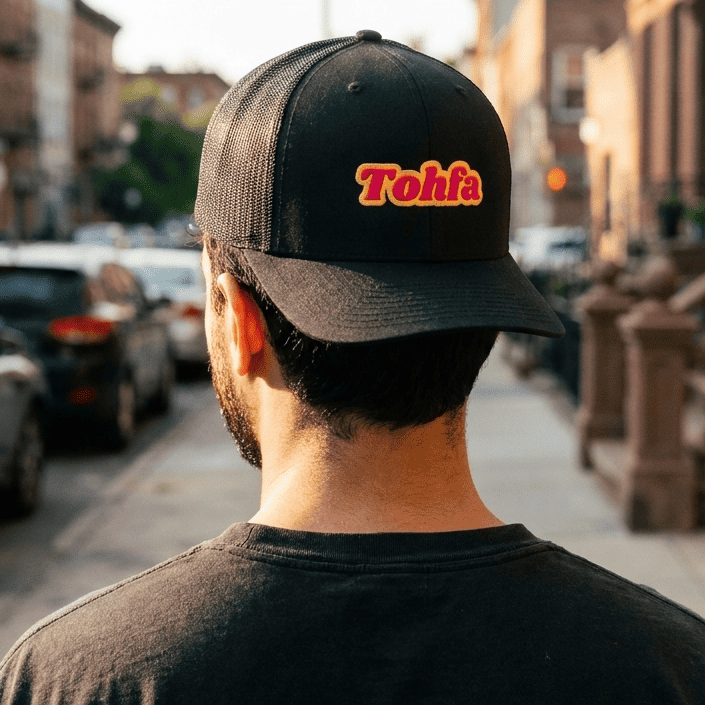 Model wearing Tohfa trucker cap, side angle, Arabic slogan headwear by BOSA